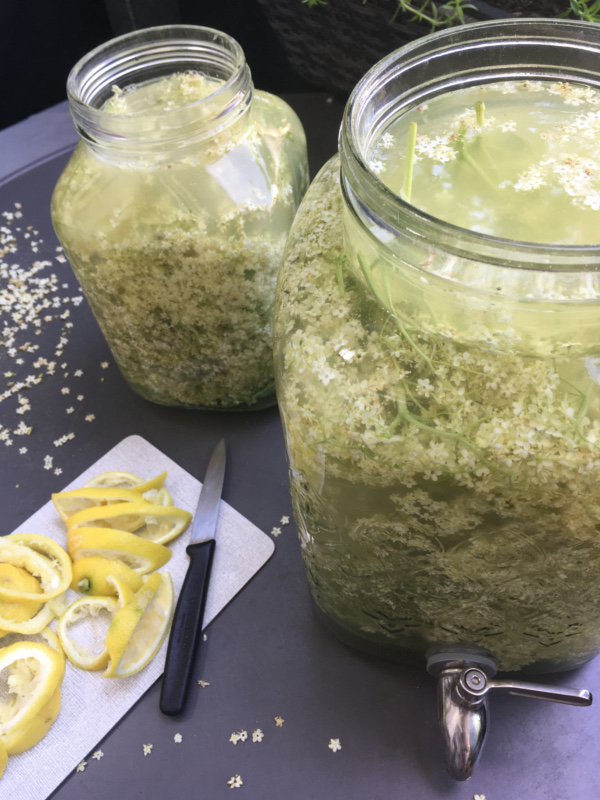 Jahresrückblick 2021 -Glasbehälter gefüllt mit Holunderblüten, davor ein Brettchen mit geschnittenen Zitronen